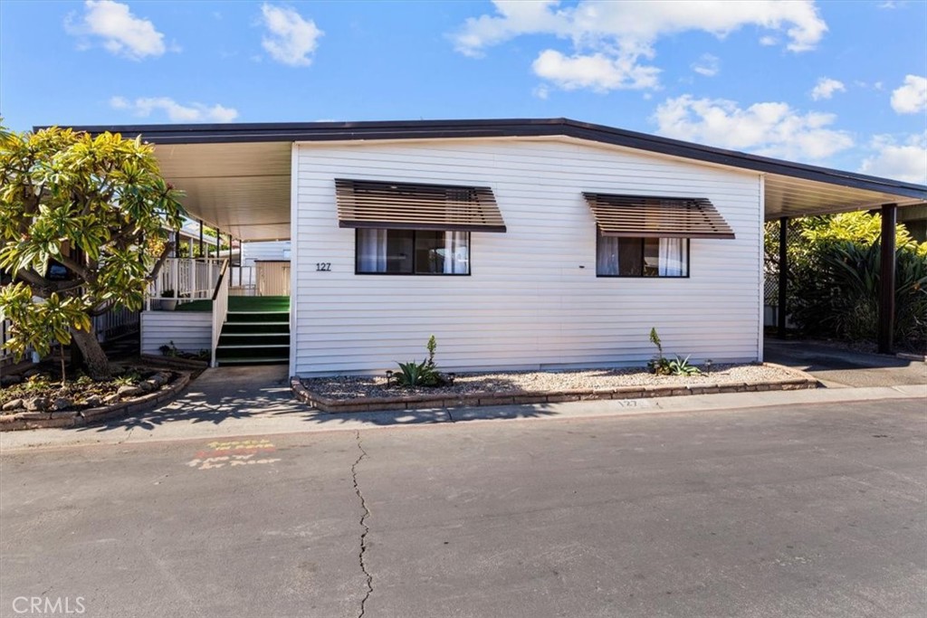 300 North Rampart Street, Unit 127 Orange, CA 92868 - Photo 4 of 28 Exterior view of the home at 300 N Rampart St TRAILER 127, Orange, CA. Features a covered porch/carport area and well-maintained landscaping