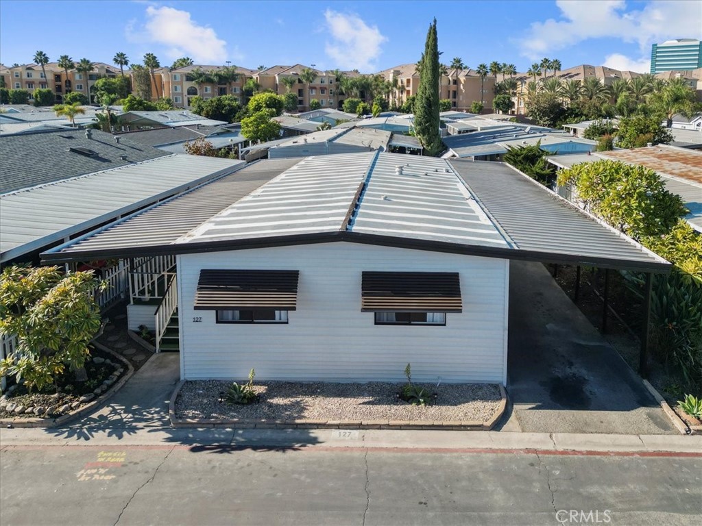 300 North Rampart Street, Unit 127 Orange, CA 92868 - Photo 4 of 37 Exterior view of the home at 300 N Rampart St TRAILER 127, Orange, CA. Features a covered porch/carport area and well-maintained landscaping