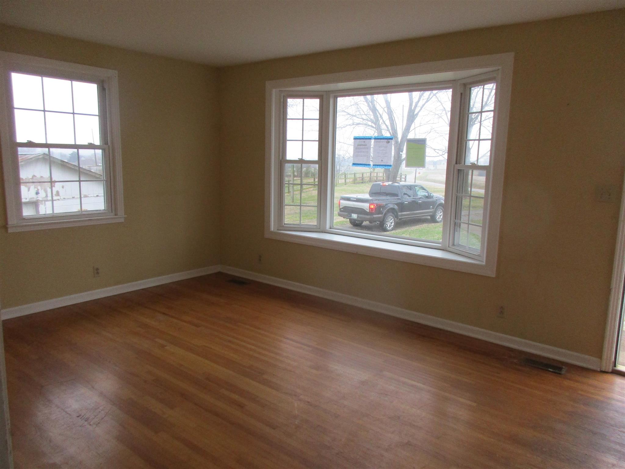 3779 Buck Road Clarksville, TN 37043 - Photo 6 of 12 a view of an empty room with wooden floor and a window
