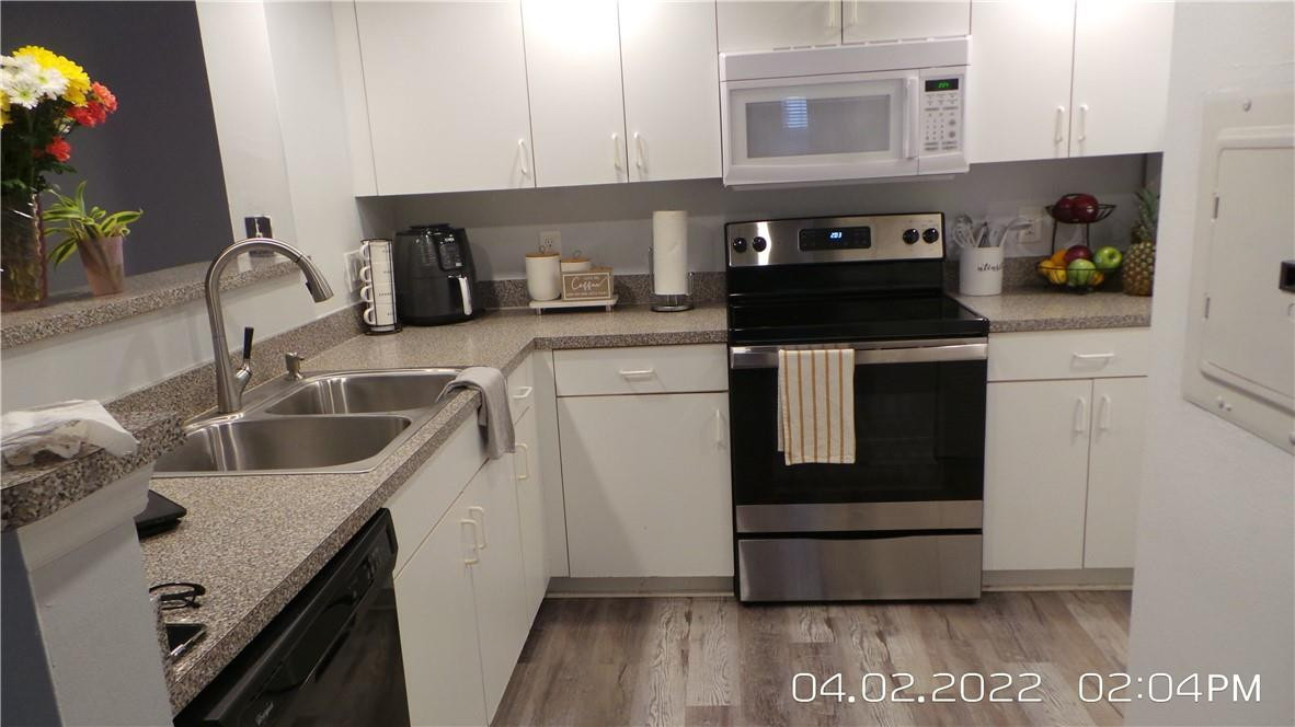 5001 Wiles Road, Unit 106 Pompano Beach, FL 33073 - Photo 1 of 31 a kitchen with a sink stove and cabinets