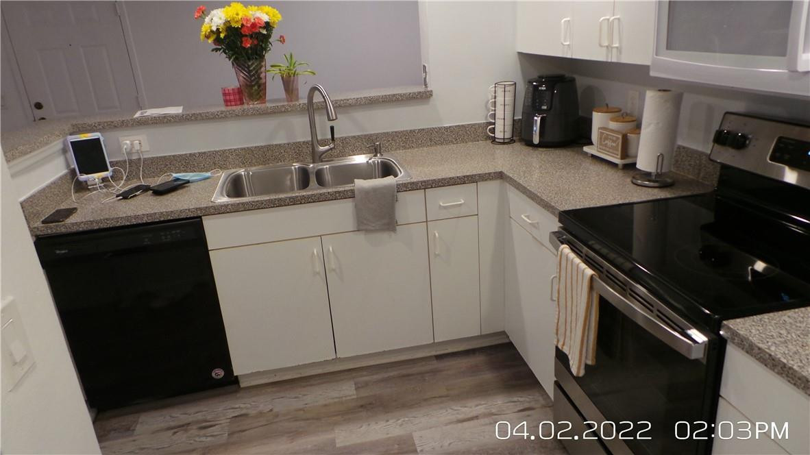 5001 Wiles Road, Unit 106 Pompano Beach, FL 33073 - Photo 2 of 31 a kitchen with a sink and cabinets