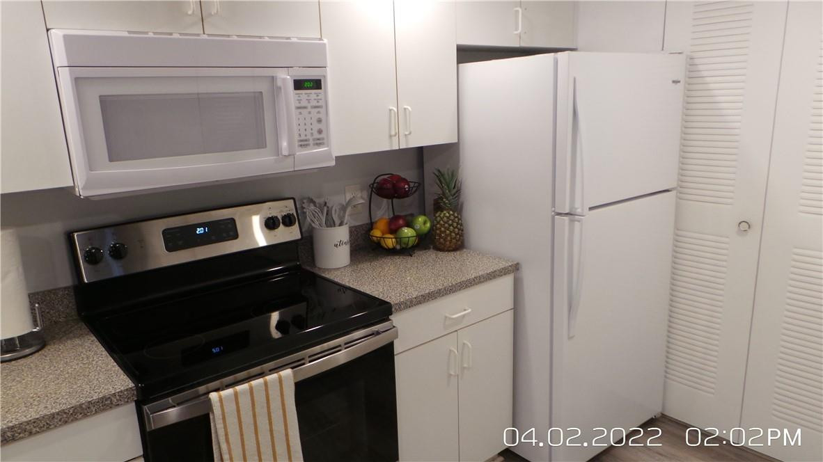 5001 Wiles Road, Unit 106 Pompano Beach, FL 33073 - Photo 3 of 31 a kitchen with a refrigerator stove and microwave