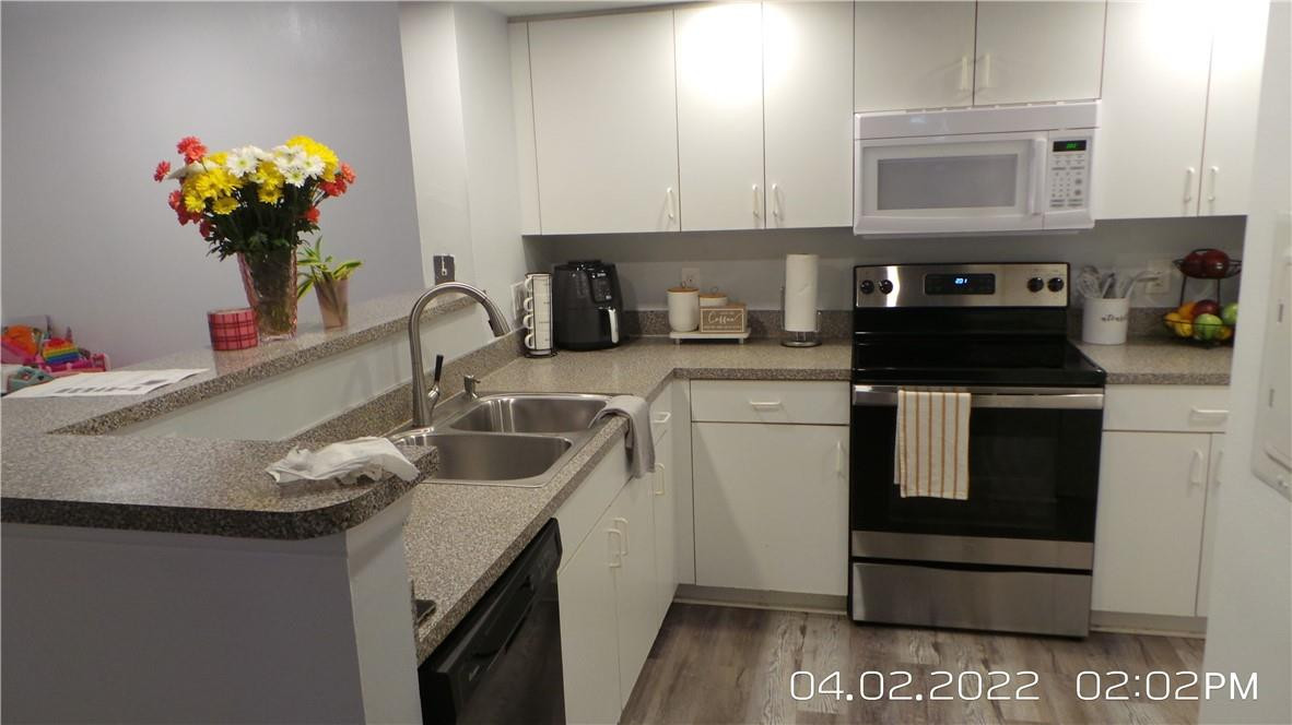 5001 Wiles Road, Unit 106 Pompano Beach, FL 33073 - Photo 4 of 31 a kitchen with a sink a stove and cabinets