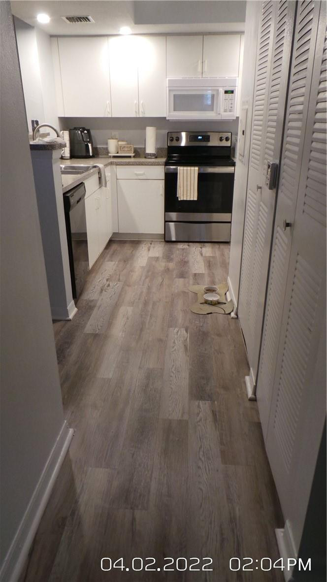5001 Wiles Road, Unit 106 Pompano Beach, FL 33073 - Photo 5 of 31 a kitchen with granite countertop a refrigerator a sink and white cabinets