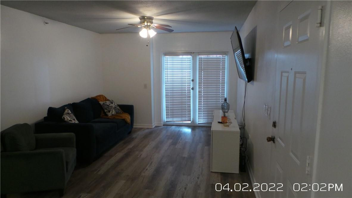 5001 Wiles Road, Unit 106 Pompano Beach, FL 33073 - Photo 6 of 31 a living room with furniture and a chandelier