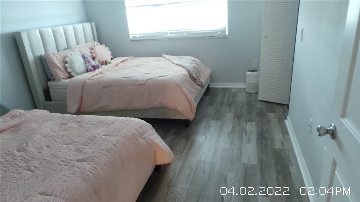 5001 Wiles Road, Unit 106 Pompano Beach, FL 33073 - Photo 10 of 31 a bed sitting in a bedroom next to a window
