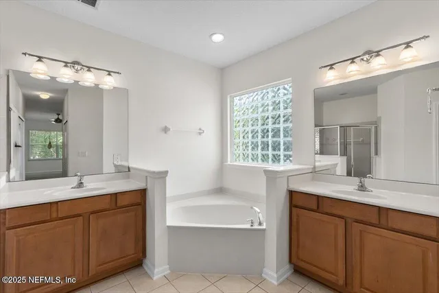 a bathroom with a sink double vanity mirror and a bathtub