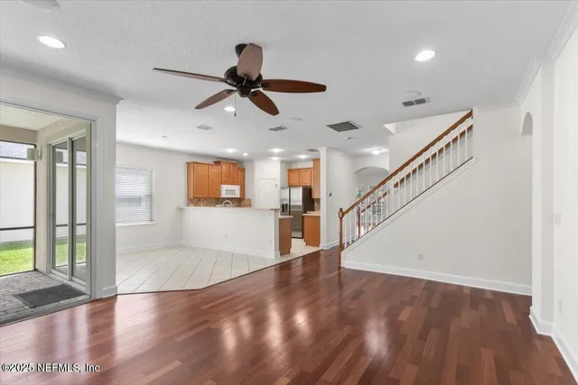 a view of a hallway with wooden floor and staircase