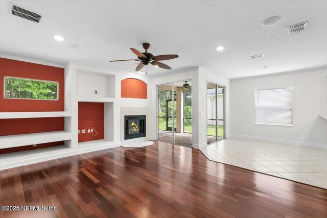 a view of an empty room with a fireplace and a window