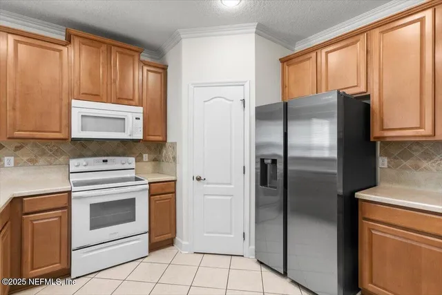a kitchen with stainless steel appliances granite countertop a refrigerator and a stove top oven