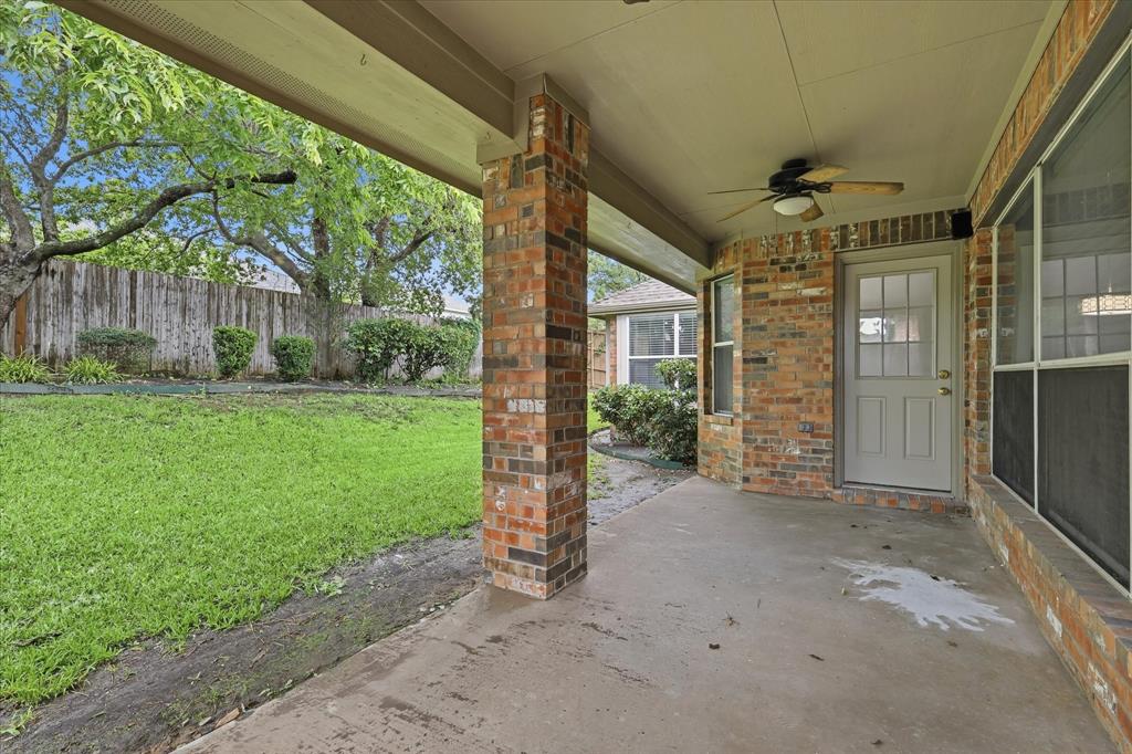 2616 Hollow Ridge Drive Denton, TX 76210 - Photo 29 of 31 Covered patio featuring a brick column, ceiling fan, and a light-colored exterior door with glass inserts