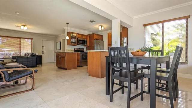 a dining room with furniture and large windows