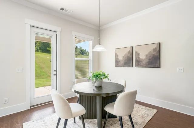 a kitchen with stainless steel appliances refrigerator dining table and chairs