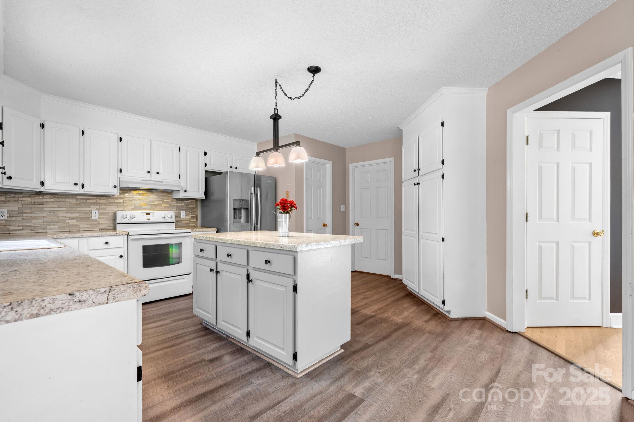 712 Painted Feather Lane Conover, NC 28613 - Photo 12 of 48 a kitchen with cabinets wooden floor and stainless steel appliances