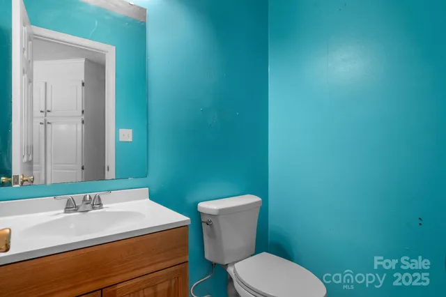 a bathroom with a granite countertop toilet and a sink
