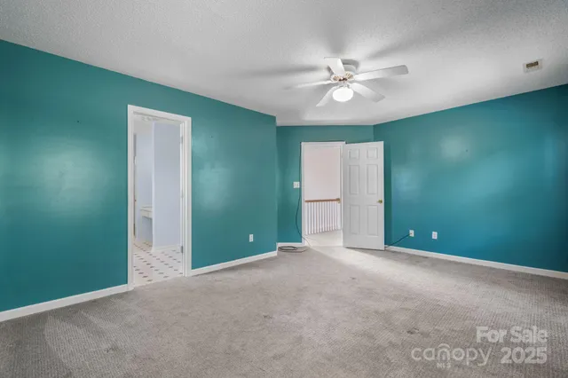 an empty room with closet and a chandelier fan