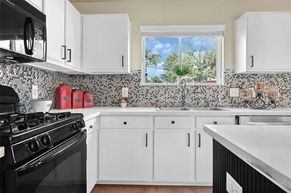 a kitchen with stainless steel appliances white cabinets and a stove top oven
