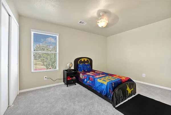 a bedroom with a bed and a lamp next to a window