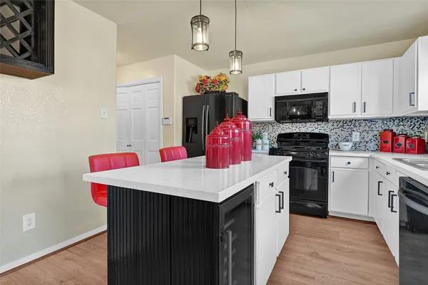 a kitchen with stainless steel appliances kitchen island granite countertop a sink dishwasher and a stove with wooden floor