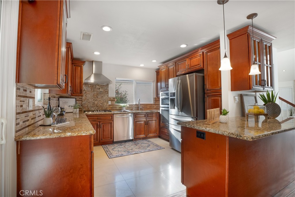 6 Sanderling Irvine, CA 92604 - Photo 12 of 35 a kitchen with stainless steel appliances granite countertop a sink refrigerator and cabinets