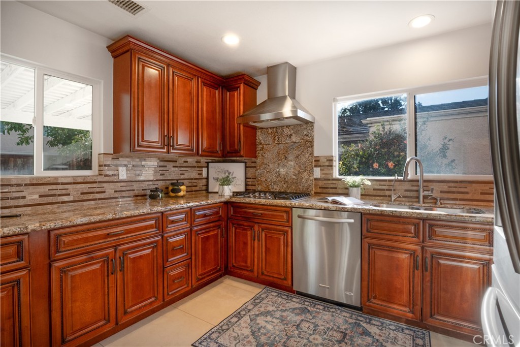 6 Sanderling Irvine, CA 92604 - Photo 15 of 35 a kitchen with stainless steel appliances granite countertop wooden cabinets a sink and a large window