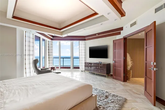 a large white kitchen with a large window and refrigerator