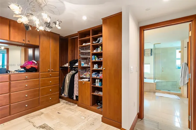 a view of walk in closet with clothes and shoes