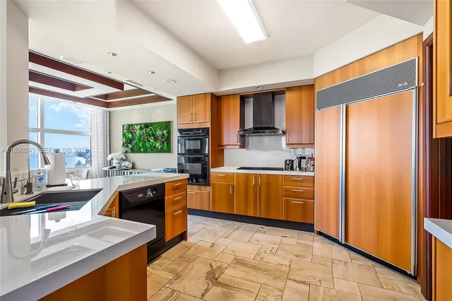 a living room with furniture a flat screen tv and a refrigerator