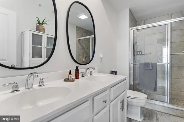 a bathroom with a toilet a sink a mirror and a shower