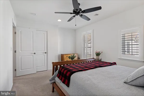 a bedroom with a bed and a ceiling fan