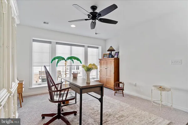 a view of a livingroom with furniture and a ceiling fan