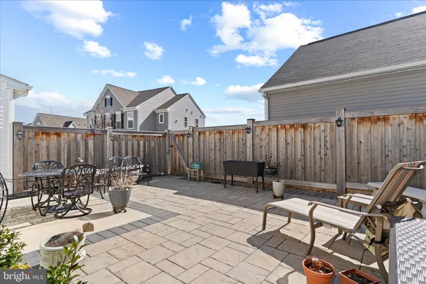 a view of a patio with table and chairs with wooden fence