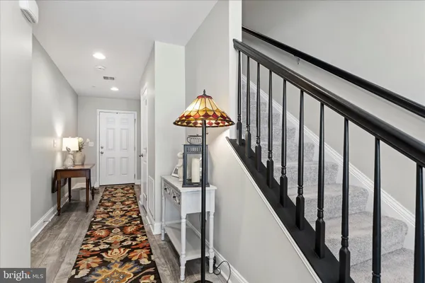 a hallway with wooden floor stairs and furniture
