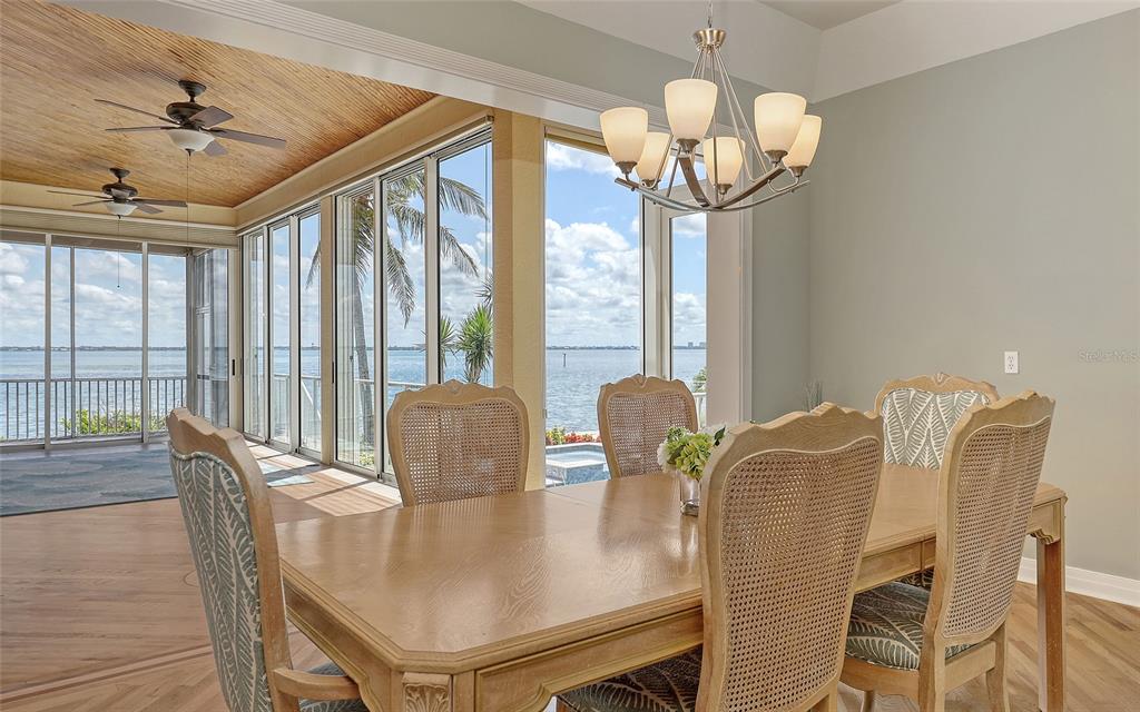 585 Gunwale Lane Longboat Key, FL 34228 - Photo 24 of 73 a view of a dining room with furniture large windows and wooden floor