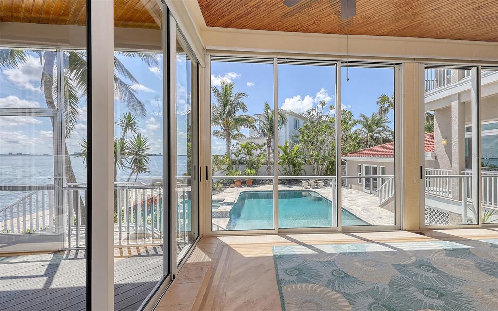 585 Gunwale Lane Longboat Key, FL 34228 - Photo 35 of 73 a view of a porch with a floor to ceiling window and wooden floor