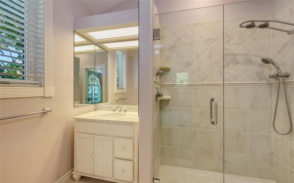 585 Gunwale Lane Longboat Key, FL 34228 - Photo 40 of 73 a bathroom with a shower sink and mirror
