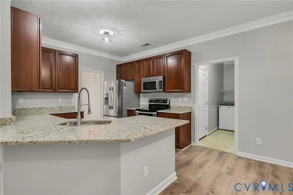 a kitchen with stainless steel appliances granite countertop wooden cabinets a sink and dishwasher