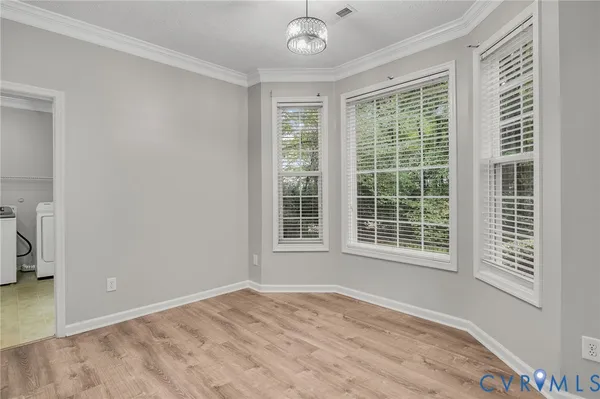 a view of an empty room with wooden floor fireplace and a window