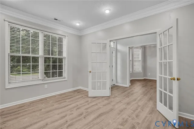 a view of empty room with wooden floor and windows