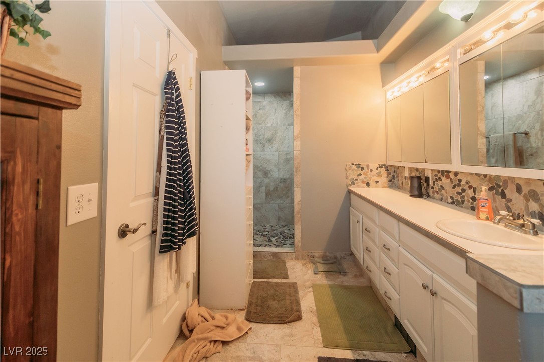 3485 Gally Road Pahrump, NV 89060 - Photo 50 of 90 Bathroom with double vanity, tiled shower, and backsplash