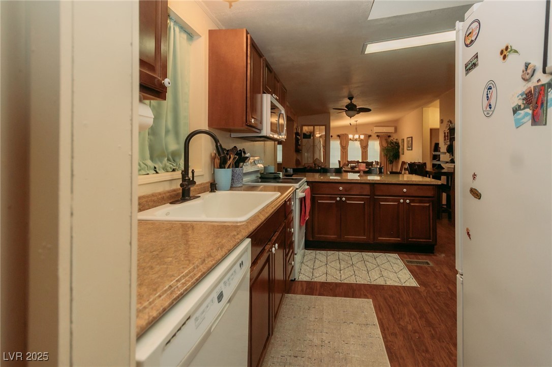 3485 Gally Road Pahrump, NV 89060 - Photo 53 of 90 Kitchen featuring white appliances, dark wood-style floors, a peninsula, and a ceiling fan