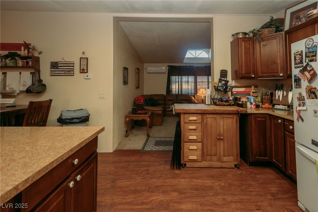 3485 Gally Road Pahrump, NV 89060 - Photo 54 of 90 Kitchen with light countertops, dark wood-style flooring, freestanding refrigerator, and a peninsula