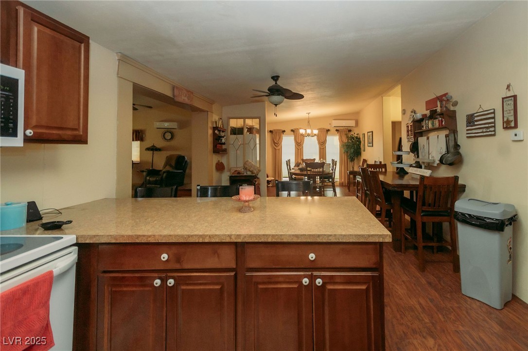 3485 Gally Road Pahrump, NV 89060 - Photo 61 of 90 Kitchen featuring a peninsula, ceiling fan, dark wood-type flooring, a chandelier, and light countertops
