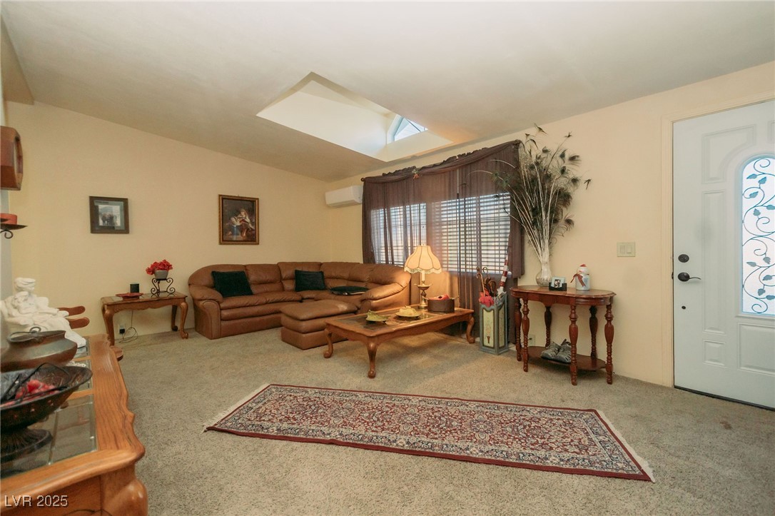 3485 Gally Road Pahrump, NV 89060 - Photo 62 of 90 Living room featuring carpet, a skylight, lofted ceiling, and an AC wall unit