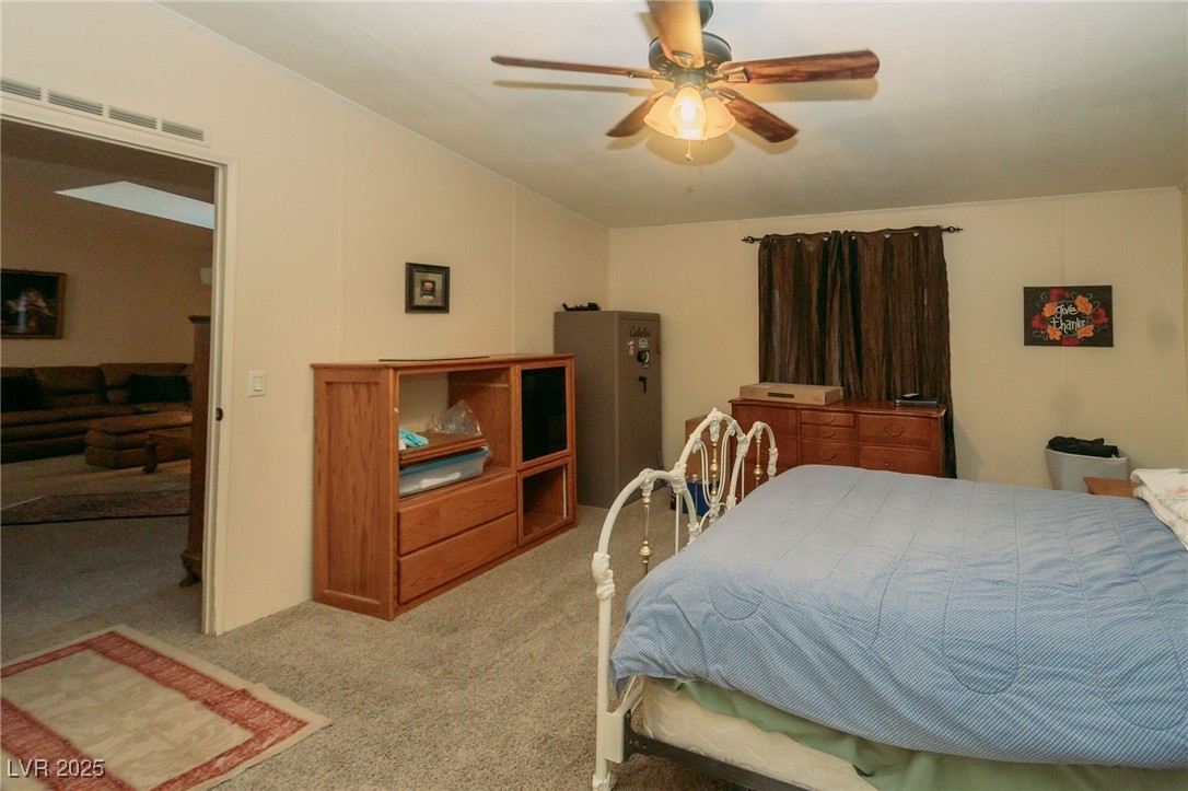3485 Gally Road Pahrump, NV 89060 - Photo 68 of 90 Bedroom featuring light carpet, vaulted ceiling, and a ceiling fan