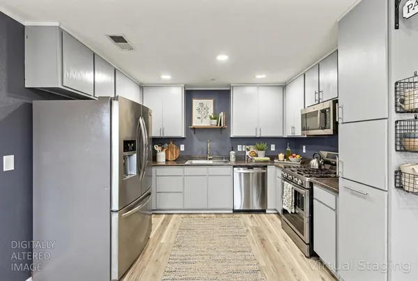a kitchen with stainless steel appliances granite countertop a refrigerator and a sink