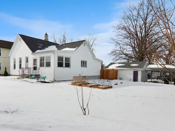 a view of a white house with snow on the road