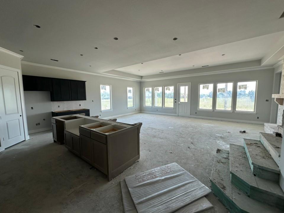 295 Brown Road Leonard, TX 75452 - Photo 7 of 26 Open-concept living space featuring a tray ceiling, recessed lighting, crown molding, and multiple large windows