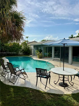 a view of a house with swimming pool and sitting area