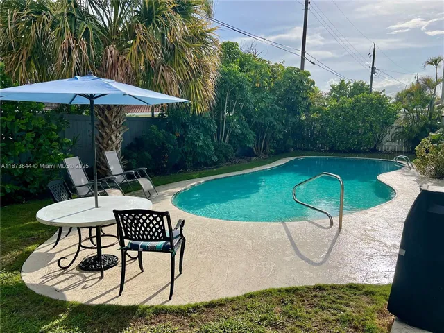 a patio with a table and chairs under an umbrella